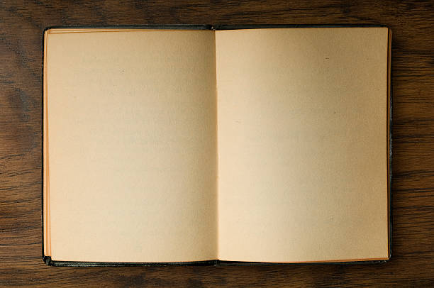 Old Open Book with Yellowed Blank Pages on Dark Wood Background.